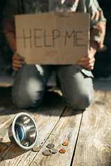 Image showing Male beggar hands seeking money on the wooden floor at public path way