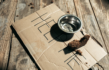 Image showing Male beggar hands seeking money on the wooden floor at public path way