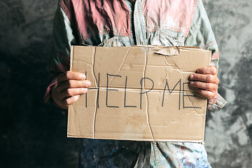 Image showing Male beggar hands seeking money on the wooden floor at public path way