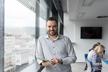 Image showing Businessman Using Tablet In Office Building by window