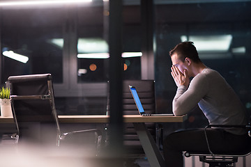 Image showing man working on laptop in dark office