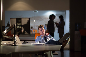 Image showing businessman sitting with legs on desk at office