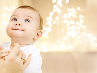 Image showing close up of sweet baby over christmas lights