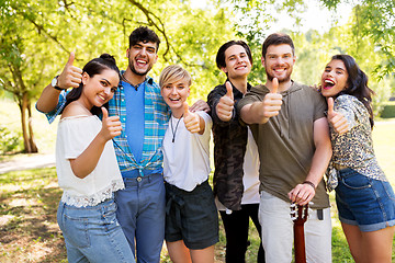 Image showing friends with guitar showing thumbs up at park