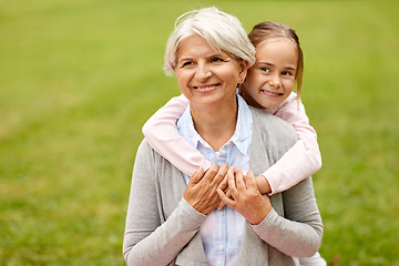 Image showing granddaughter hugging grandmother at summer park