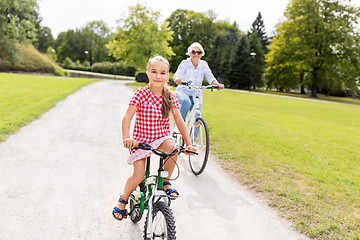 Image showing grandmother and granddaughter cycling at park