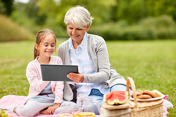 Image showing grandmother and granddaughter with tablet at park