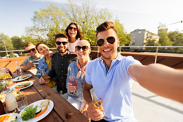 Image showing happy friends taking selfie at rooftop party