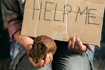 Image showing Male beggar hands seeking money on the wooden floor at public path way