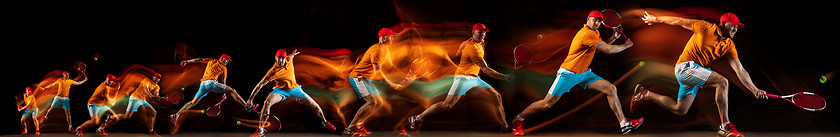 Image showing One caucasian man playing tennis on black background