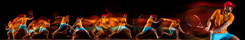 Image showing One caucasian man playing tennis on black background