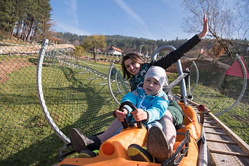 Image showing mother and son enjoys driving on alpine coaster