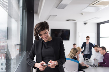 Image showing Elegant Woman Using Mobile Phone by window in office building