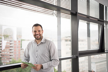 Image showing Businessman Using Tablet In Office Building by window