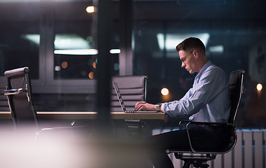 Image showing man working on laptop in dark office