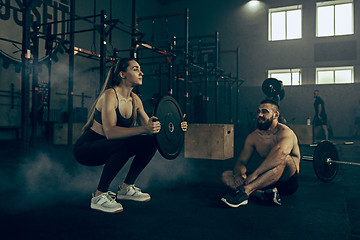 Image showing Fit young woman lifting barbells working out in a gym