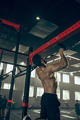 Image showing Concept: power, strength, healthy lifestyle, sport. Powerful attractive muscular man at CrossFit gym