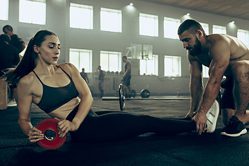 Image showing Fit young woman lifting barbells working out in a gym