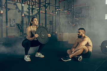 Image showing Fit young woman lifting barbells working out in a gym