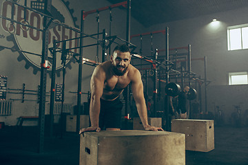 Image showing Man during exercises in the fitness gym. CrossFit.