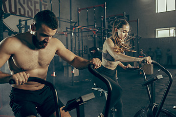 Image showing Man and woman during exercises in the fitness gym. CrossFit.