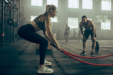 Image showing Woman with battle ropes exercise in the fitness gym.