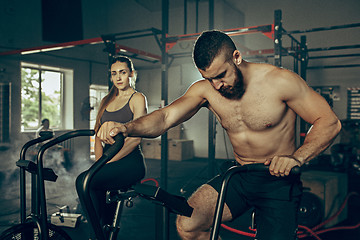 Image showing Man and woman during exercises in the fitness gym. CrossFit.