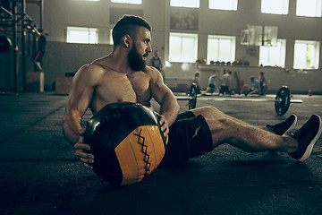 Image showing Fit young man lifting barbells working out in a gym