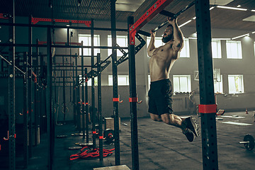 Image showing Concept: power, strength, healthy lifestyle, sport. Powerful attractive muscular man at CrossFit gym