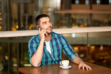 Image showing man with coffee calling smartphone at restaurant