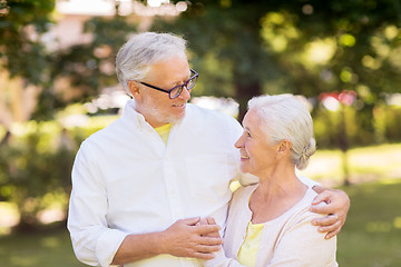 Image showing happy senior couple hugging at summer park