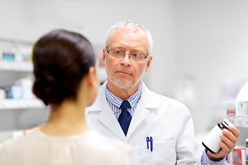 Image showing apothecary showing drug to customer at pharmacy