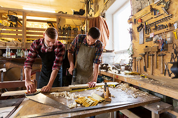 Image showing carpenters working with wooden board at workshop