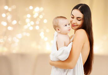 Image showing close up of mother with baby over christmas lights