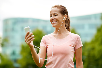 Image showing woman listening to music on smartphone at park