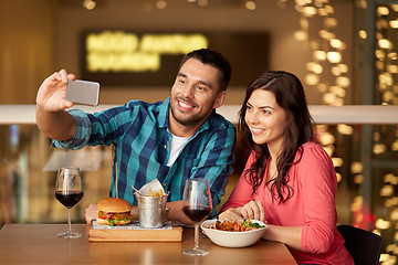 Image showing couple taking selfie by smartphone at restaurant