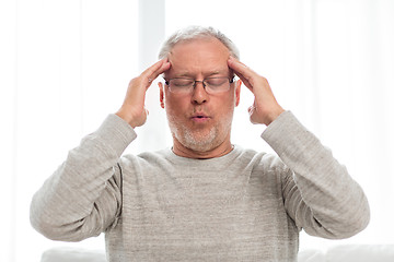 Image showing senior man suffering from headache at home