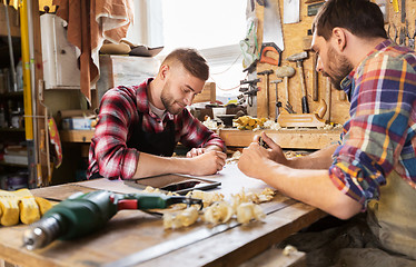 Image showing carpenters with blueprint working at workshop