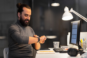 Image showing man with smartwatch and computer at night office