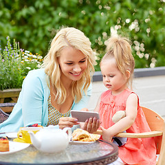 Image showing mother and baby daughter with smartphone at cafe