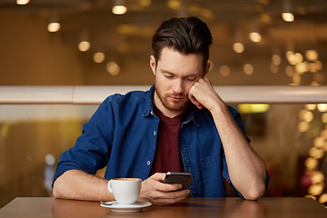 Image showing sad man with coffee and smartphone at restaurant