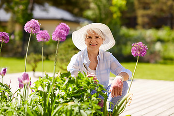 Image showing senior woman with garden pruner and flowers