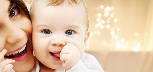 Image showing close up of mother with baby over christmas lights