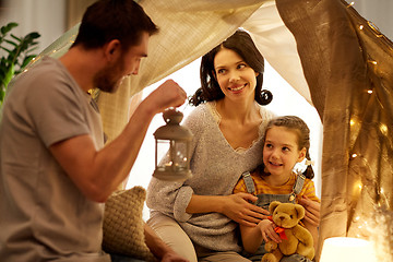 Image showing happy family playing in kids tent at night at home