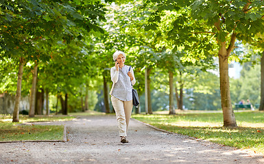 Image showing senior woman calling on smartphone in summer park