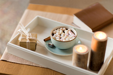 Image showing hot chocolate, christmas gift and candles on table