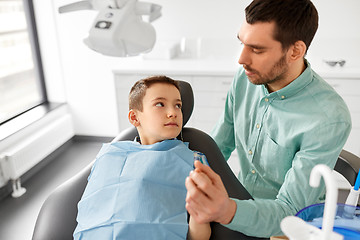 Image showing father supporting son at dental clinic