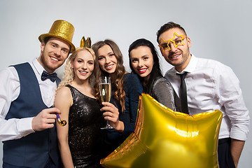 Image showing happy friends with golden party props posing