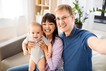 Image showing mixed race family with baby taking selfie at home