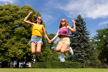 Image showing happy teenage girls jumping at summer park